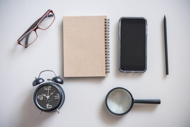 Blank notebook is on top of white office table.