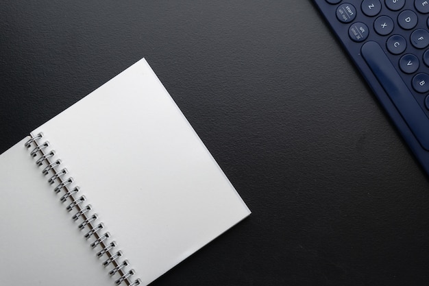 Blank notebook and keyboard on desk