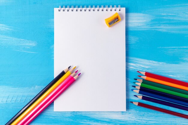 Blank notebook page with pencils, markers, copy space. back to school concept with office supplies