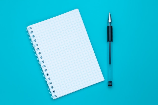 Blank notebook and pen on blue background. Copy space. Education concept.