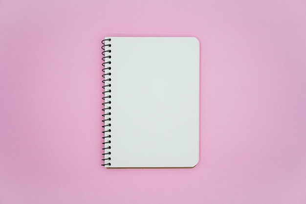 Photo blank notebook on pink background. top view.