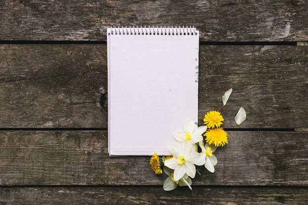 Photo blank notebook with flower on vintage wooden table