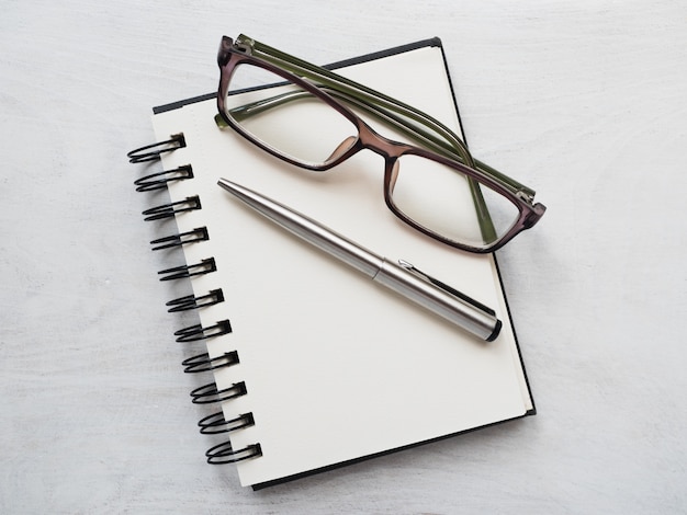 Blank notebook with glasses and pen