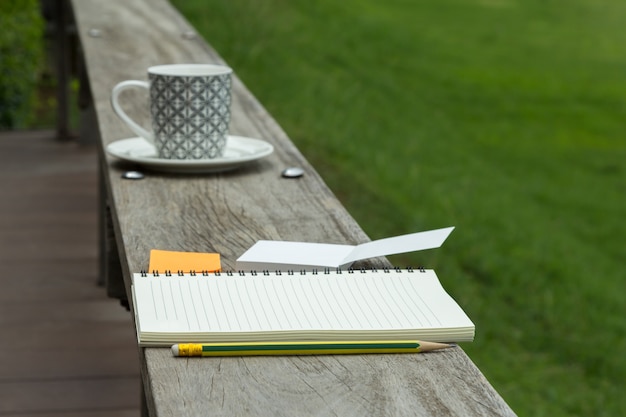 blank notebook with notepad and pencil on wooden