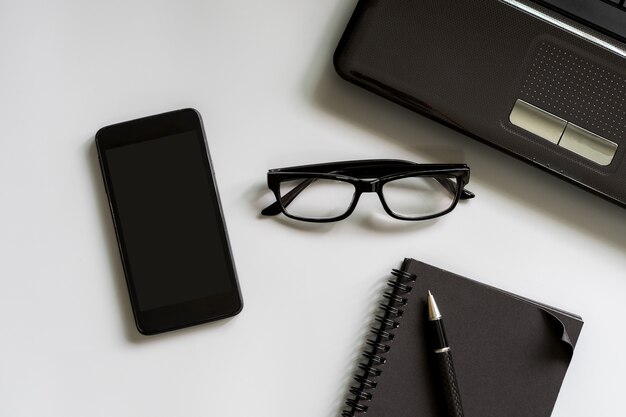 Blank notebook with smart phone and laptop desk office