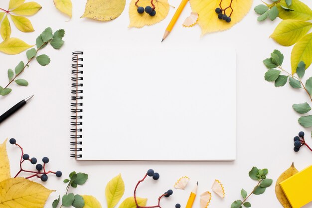 Blank notepad in autumn leaves frame