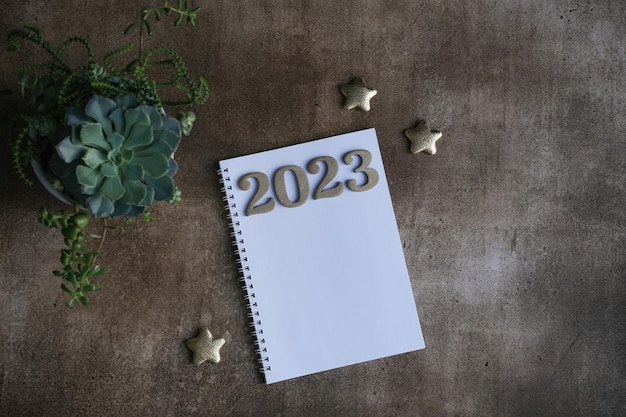 Blank notepad mockup and 2023 gold colored numbers Wish list and goals for 2023