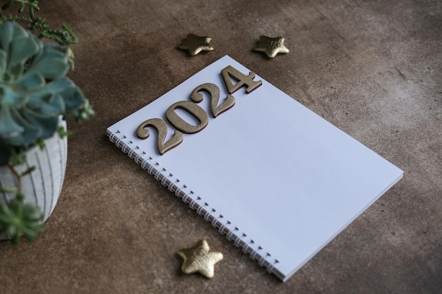 Blank notepad mockup and 2024 gold colored numbers Wish list and goals for 2024