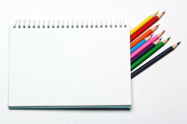 Blank notepad and pencil color on a table blackground