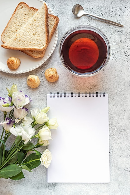 A blank notepad sheet with breakfast setting and flowers