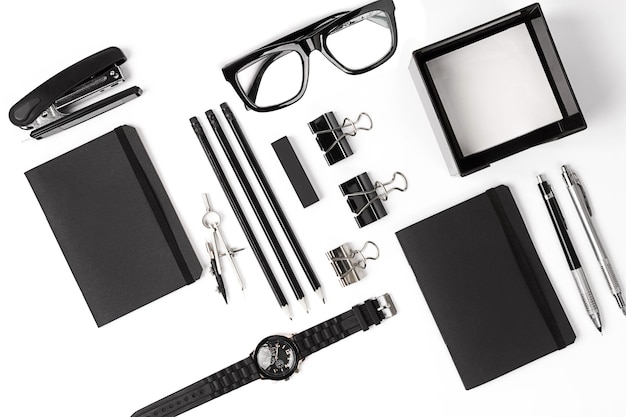 blank notepad with clips, pens and glasses flat lay.