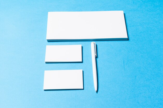 Blank office objects organized for company presentation on blue paper background