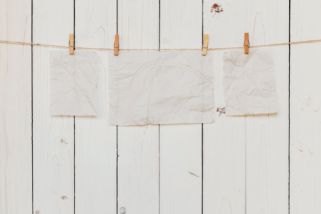 Foto vecchia carta vuota appesa su sfondo bianco di legno con spazio per il testo.