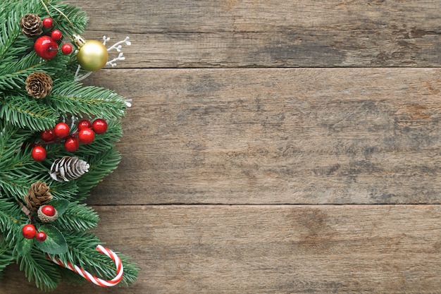 Blank old wood texture decorate with pine leaves, and cone, holly balls, golden ball and candy cane.