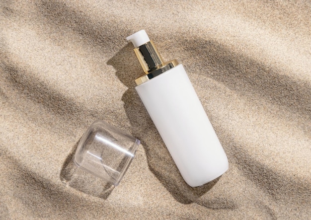 Blank one pump Cream bottle on beige sand close up hard light Cosmetic mockup