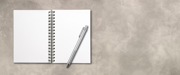 Blank open spiral notebook mockup and pen isolated on concrete