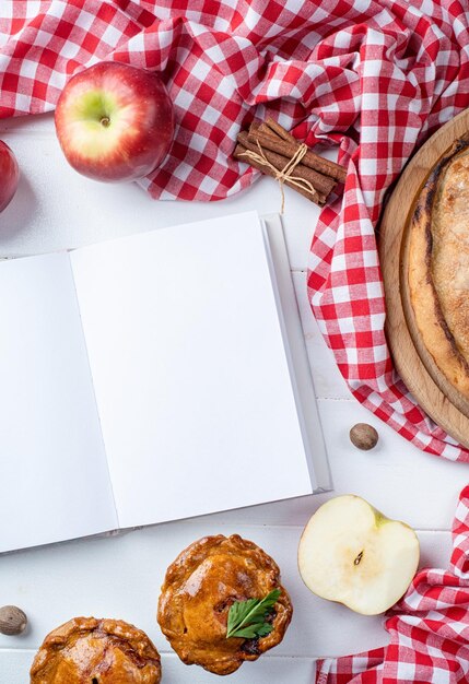 Foto mockup di libro di cucina aperto in bianco con torta di carne di torta di mele e frutta di stagione