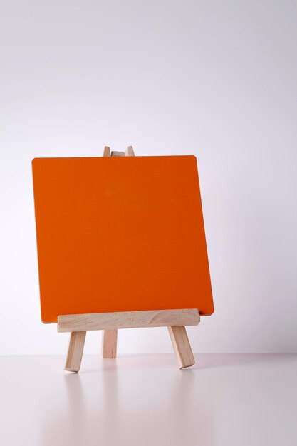 Blank orange board on table against white background