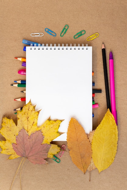 Foto pagina vuota, matite colorate, pennarelli, foglie di autunno, penna