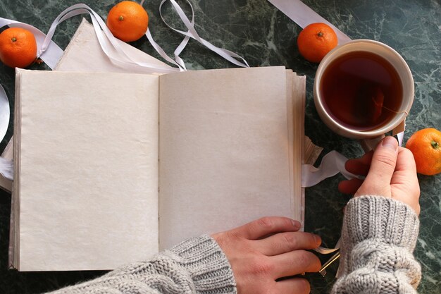 Blank pages opened vintage book on green marble countertop