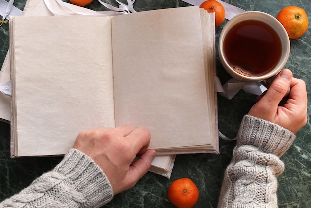 Blank pages opened vintage book on green marble countertop