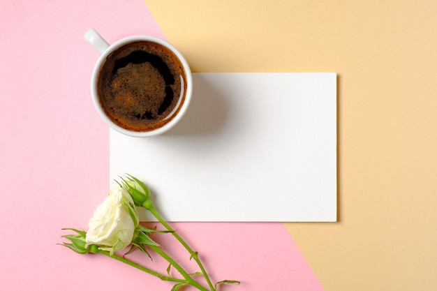 Blank paper card with copy space, cup of coffee and white roses flowers