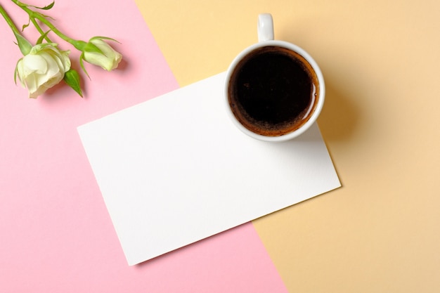 Blank paper card with copy space, cup of coffee and white roses flowers