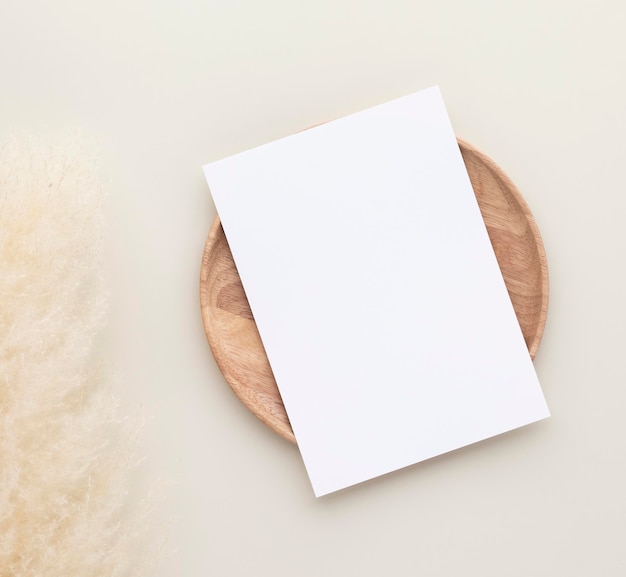 Foto schede di carta bianche, mockup con erba di pampa su un piatto di legno, sfondo beige, composizione minima del posto di lavoro beige, disposizione piatta, mockup