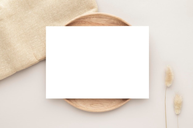 Photo blank paper cards, mockup with pampas grass on a wooden plate, beige background, minimal beige workplace composition, flat lay, mockup