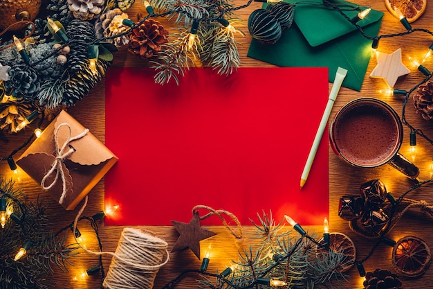 Blank paper Christmas letter to or from Santa surrounded by Christmas decorations with hot chocolate