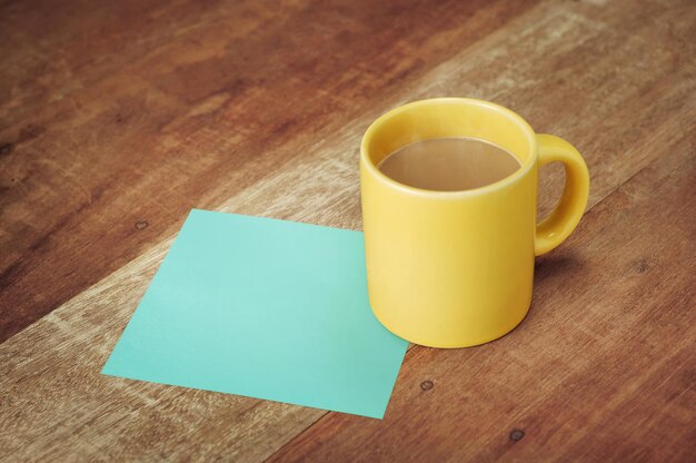 Blank paper and coffee mug on wood table