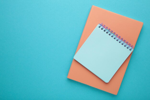 Blank paper notebook on blue background Office desk table concept