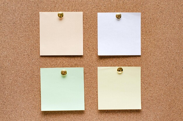 Blank paper notes are pinned to a cork board Copy space