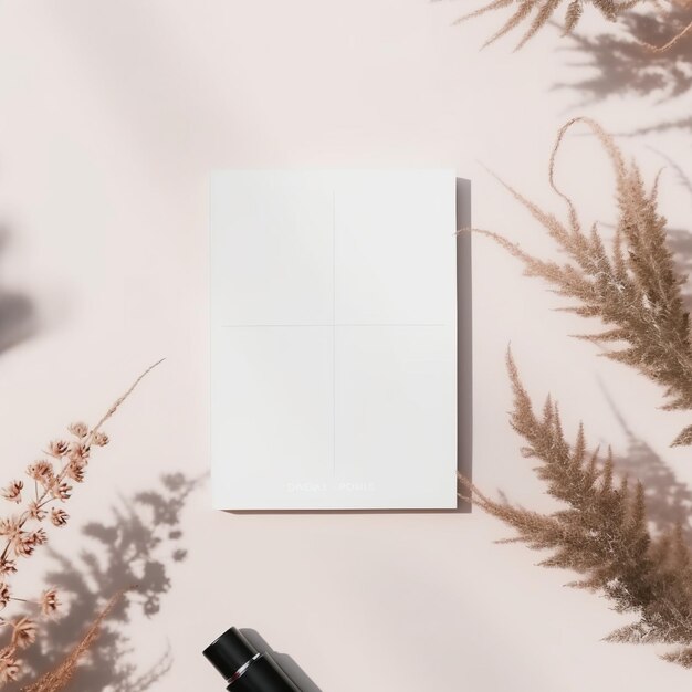 Photo blank paper on a pink background with dried plants and a black perfume bottle