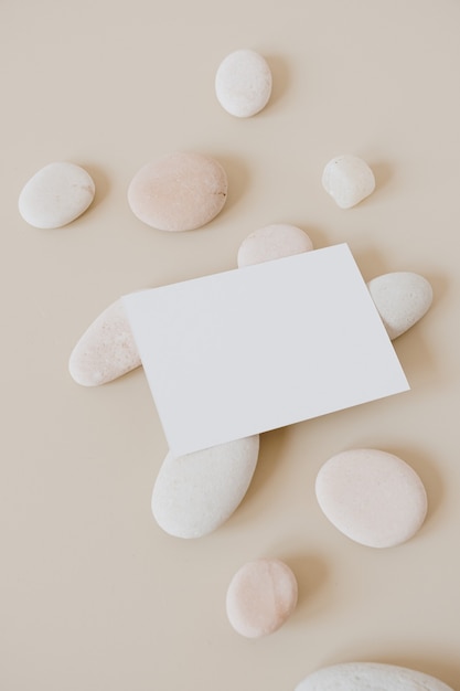 Blank paper sheet card with stones on beige