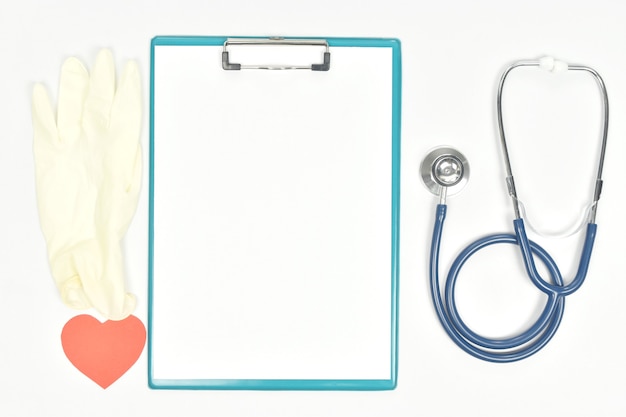 Photo blank paper sheet on clipboard and stethoscope medical gloves heart shape on white background