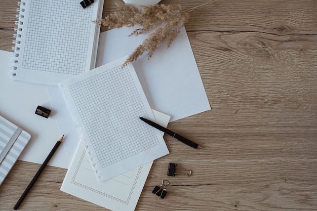 Blank paper sheet on table. Artist home office desk workspace with pencil, pampas grass