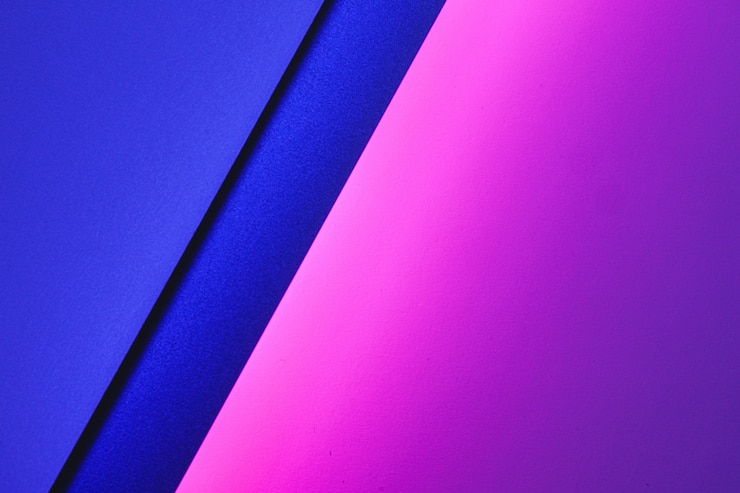 Photo blank paper sheets rolled in a neon purple lighting close up