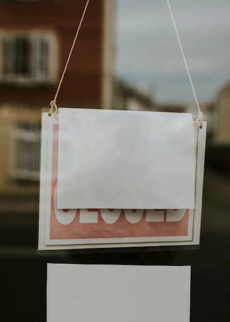 Photo blank paper sign hanging on a closed shop window