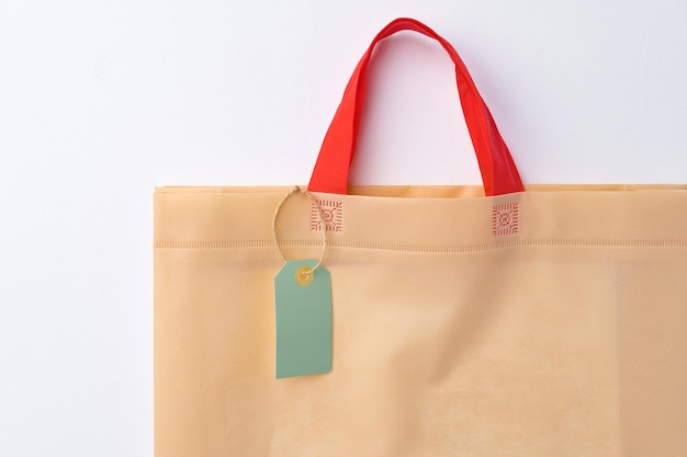 Blank paper tag with shopper paperbag on white background