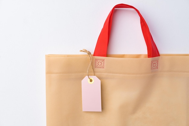 Blank paper tag with shopper paperbag on white background