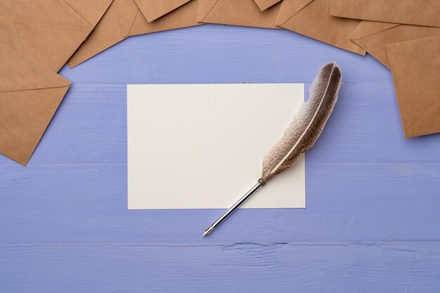 Фото Пустая бумага с перьем и конвертами на лавандовом деревянном столе