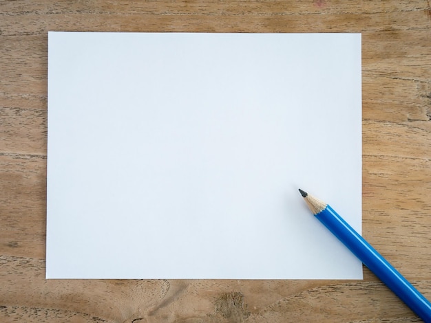 Foto blank papier met potlood op een houten tafel.