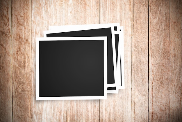Blank photo frame on brown wood background top view with cop space for any and travel concept