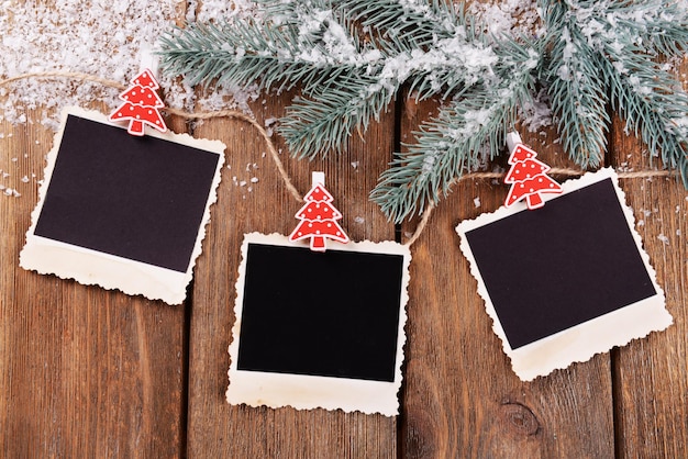 Photo blank photo frames and christmas decor with snow fir tree on wooden table background