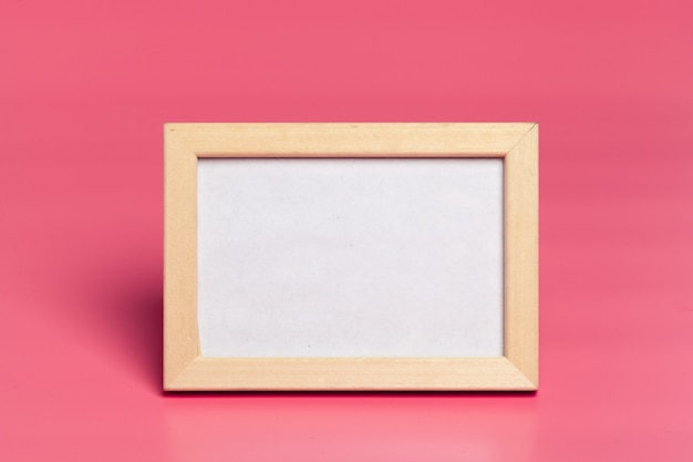 Blank photo frames on pink colored background