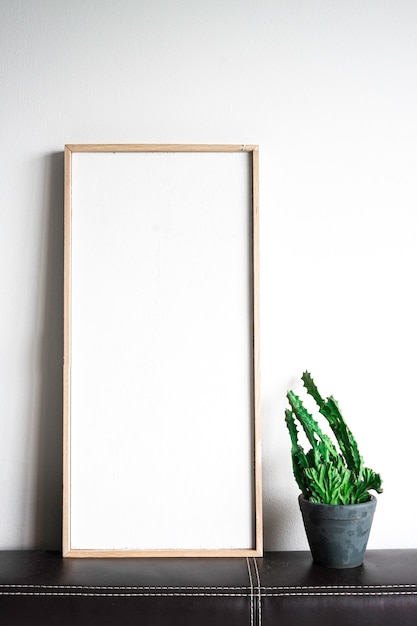 Blank picture frame and cactus plant, copy space for text.