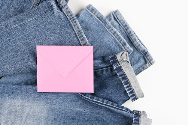 Blank pink envelope on blue jeans background with copyspace for sale text or business isolated on white top view High quality photo