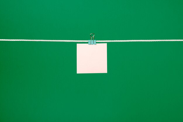 Photo blank pink paper note on clothesline