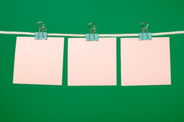 Blank pink paper sheets hanging on string